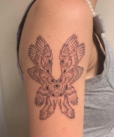 a woman with a tattoo on her arm that has an eagle and flowers on it