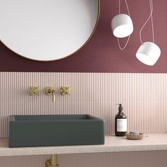 a bathroom with a sink, mirror and two lights hanging from it's ceiling