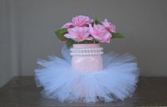 pink roses in a mason jar with tulle and pearls on the bottom, sitting on a shelf