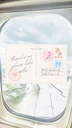 an airplane window with a postcard attached to it