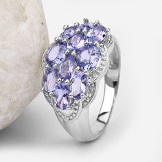 "Tanzanite Ring, Real Tanzanite Cluster Ring in .925 Sterling Silver with Rhodium Plating, for Women, December Birthstone Ready for radiance? Add a flash of radiance with this glittering cluster ring. The ring features a sensational jewel cluster made up of 10 oval-cut purple tanzanite stones. The gemstones have a combined weight of 2.66 carats, and the band is crafted from .925 sterling silver with a rhodium plating finish. Product Details: Metal: .925 Sterling Silver Gross Wt: 4.11 Grams Gemst Silver Tanzanite Multi-stone Rings, Silver Tanzanite Jewelry With Accent Stones, Silver Tanzanite Hallmarked Rings, Silver Multi-stone Cluster Ring In Sterling Silver, Silver Multi-stone Sterling Silver Cluster Ring, Silver Sterling Silver Cluster Ring With Gemstone, Silver Sterling Cluster Ring With Gemstones, Purple Tanzanite, Tanzanite Stone