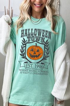 HALLOWEEN TOWN WHERE BEING NORMAL IS VASTLY OVERRATED UNISEX SHORT SLEEVE,GRAPHIC TEE,GRAPHIC TSHIRTS,TSHIRTS,TEES100%COTTON,HEATHER(52%COTTON,48%POLY),ATH.HEATHER,BLACK HEATHER(90%COTTON,572%POLY)NICARAGUAMade In: Nicaragua Fall Themed Short Sleeve T-shirt, Fall Themed T-shirt With Letter Print, Halloween Themed Tops With Crew Neck, Halloween Themed Crew Neck Tops, Pre-shrunk Themed Tops For Halloween, Casual Green Halloween Top, Themed Short Sleeve Fall Top, Themed Short Sleeve Top For Fall, Themed Long Sleeve T-shirt With Letter Print