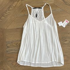 100% Rayon Tank. Floral Detail On Back. Sheer Material. New But There Is A Makeup Mark On The Interior And A Few Dots On The Tank. Shown In Photos. Casual Lace Top Camisole For Vacation, Casual Lace Top Camisole For The Beach, Casual Lace Top Camisole For Day Out, Casual White Camisole Blouse, Sheer Material, On Back, Color White, Dots, Womens Tops