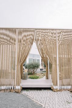 the entrance to an outdoor ceremony with wicker curtains