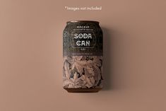 a can of soda sitting on top of a brown table next to a pink wall