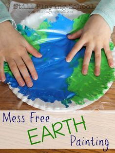 a child's hands on top of a paper plate with the words mess free earth painting