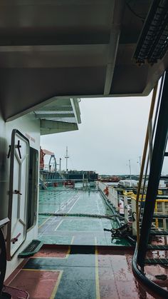 the inside of a boat looking out at the water and boats in the dock area