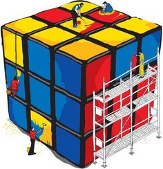 a giant rubik cube being worked on by a man with a scaffolding machine