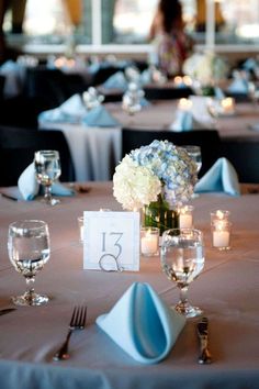 the table is set with candles, flowers and place settings for guests to sit at