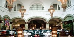 the interior of a restaurant with chandeliers and tables