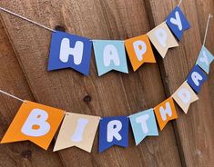 a happy birthday banner hanging on a wooden fence