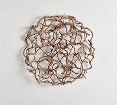 a sculpture made out of branches on a white wall