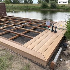 a wooden deck is being built by the water