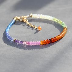 So fun and colorful this dainty beaded bracelet features melange of gems in rainbow hues. From one end to the other the gems used are: blue topaz, tanzanite, amethyst, pink sapphire, carnelian, garnet,  spessonite orange garnet, Ethiopian opal, citrine, peridot and arranged in sections. Made adjustable from7.25 to 8.5 inches.   Great on its own or layered with other gemstone bracelets. Awesome gift! gems  from 2 -3.5mm Thank you for looking! Please contact me if you have any questions or request Adjustable Rainbow Gemstone Bracelet, Rainbow Multi-stone 14k Gold Jewelry, Elegant Rainbow Multi-stone Bracelets, Multicolor Hand-strung Agate Crystal Bracelet, Stacking Jewelry, Elegant Multi-stone Rainbow Gemstones, Orchid Jewelry, Nugget Bracelet, Ruby Bracelet