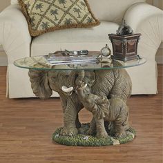 an elephant figurine sitting on top of a glass table next to a couch