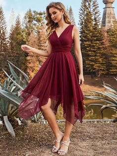 a woman in a red dress is posing for the camera with her hand on her hip