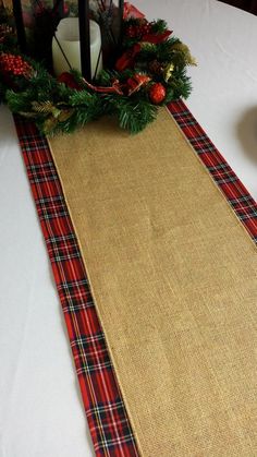 a table with a place mat, candle and christmas decorations on it's edge