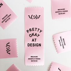 pink tags with black lettering on them that say pretty okay at design