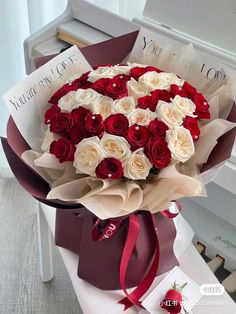 a bouquet of red and white roses in a gift box