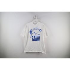 a t - shirt hanging on a hanger with the greek flag painted on it