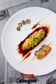 a white plate topped with food on top of a newspaper