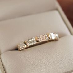 a diamond ring sitting on top of a white leather case