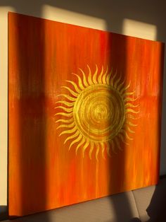 an orange and yellow painting with a sun on it