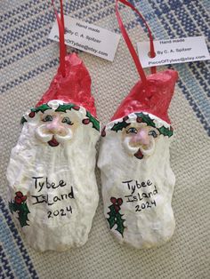 two ceramic santa claus ornaments with name tags on them