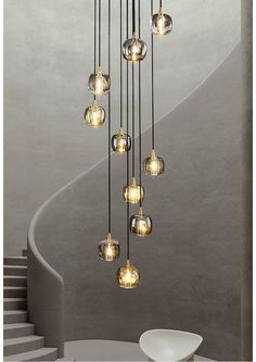 a modern chandelier with glass balls hanging from it's ceiling and spiral staircase