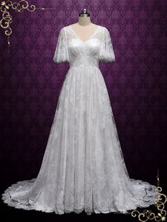 a white wedding dress on display in front of a purple background