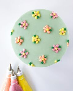 there is a cake decorated with flowers and icing next to some crayons