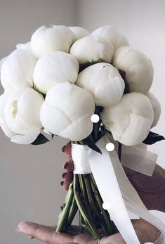 a person holding a bouquet of white flowers