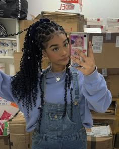 a young woman taking a selfie with her cell phone in front of cardboard boxes