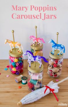 three jars filled with candy sitting on top of a wooden table