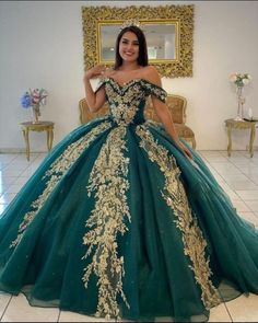 Step into a world of elegance with this captivating Dark Green Ball Gown Quinceanera Dress. This dress features a voluminous ball-gown silhouette crafted from layers of luxurious organza that flow effortlessly with every step. The deep green color adds a touch of drama and sophistication, making a bold yet timeless statement. An off-the-shoulder neckline adds a romantic flair, showcasing your shoulders and neckline gracefully. The exquisite applique details adorn the bodice, bringing intricate t 15 Emerald Green Dress, Pretty Green Quinceanera Dresses, Quinceanera Dress Emerald Green, Gold And Emerald Quinceanera, Forest Green Quinceanera Dress With Gold, Enchanted Forest Quinceanera Dresses Green, Quincenera Dresses Dark Green, Emerald Green 15 Dresses Quinceanera, Emerald Green Quinceanera Dresses With Gold