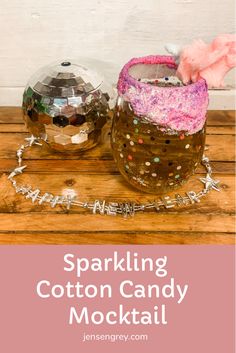 two jars filled with cotton candy sitting on top of a wooden table