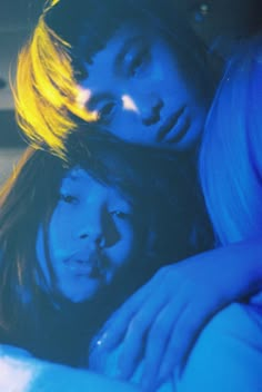 two young women laying on top of each other in front of a blue background with yellow highlights