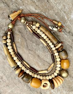 a close up of a bracelet with beads and charms on top of a stone surface