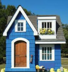 a blue and white house with flowers in the window boxes on the front door is shown