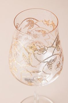 a wine glass with gold leaf designs on it