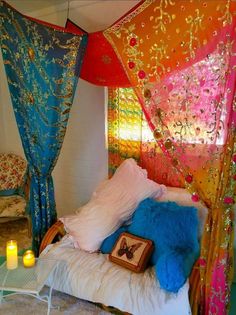 a canopy bed with pillows and candles in front of it