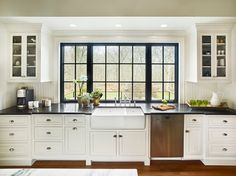 a kitchen with white cabinets and black counter tops is pictured in this image from the inside