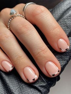 a woman's hand with pink and black french manies