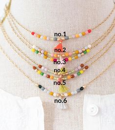 A dainty necklace made with tiny 3mm Czech glass beads in a mix of colors with a teeny tiny tassel in the center, the beads are seamlessly connected to a 24K antique gold plated chain.Choose ONE of these colors:No. 1: red, pink, mustard, pale grey, pumpkin, lilac, moss, smoke, gold with orange tasselNo.2: cream, pale grey, gold, lilac, pumpkin, moss, pink, gold with pale pink tasselNo.3: chartreuse, green, pink, pale grey, mustard, moss, pumpkin, Fuschia, gold with moss green tasselNo.4: brown, Dainty Beaded Necklace With Tiny Beads For Festivals, Bohemian Necklace With Delicate Chain And Round Beads, Dainty Tiny Beads Necklaces For Festival, Dainty Beaded Necklaces For Festival, Dainty Necklaces With Tiny Beads For Festivals, Dainty Tiny Beads Necklace For Festivals, Grey Pumpkin, Colorful Bead Bracelets, Romantic Earrings