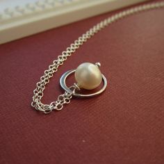 A petite freshwater pearl is encircled by a delicate sterling silver frame. Both dangle from sterling silver chain. Dainty freshwater pearl measures about 7mm; silver ring about 12mm. 18 inch necklace chain. All metal findings are *solid* sterling silver. Cultured freshwater pearl. >>To enter to my shop<< http://www.kgarnerdesigns.etsy.com Please contact me PRIOR TO PURCHASE if you are ordering on a deadline. I can usually accommodate quick shipping if I am made aware of your deadlin Delicate Pearl White Sterling Silver Necklace, Dainty Sterling Silver Pearl Charm Necklace, Sterling Silver Necklace With Pearl Charm, Minimalist Sterling Silver Pearl Drop Necklace, Dainty Sterling Silver Pearl Necklace With Round Pendant, Minimalist Sterling Silver Pearl White Necklace, Delicate Sterling Silver Pearl Necklace With Round Shape, Delicate Silver Pearl Necklace With Round Pendant, Delicate Round Pearl Necklace In Sterling Silver