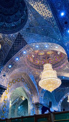 the ceiling and chandeliers in an ornately decorated building are lit up with blue lights