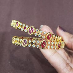 "PLS. NOTE: PRICE IS QUOTED FOR PINK BANGLES.  * Handcrafted Gold Plated Bangle Set * High Quality 22 K Gold Plated 2 pc bangle set; * Sold as a set of 2 bangles Bangles Sizes :  2.4 ( 2.31\" inner circle diameter) ; 2.6 ( 2.43\" diameter of inner circle); 2.8 (2.54\" diameter of inner circle) The gorgeous gold-plated bangle/ bracelet best exemplifies the careful craftsmanship done on it -- a specialty at Nemali Jewelry. It has a special tone of elegance attached to it. The intricate handmade de Pink Ruby Round Bracelets, Pink Hand-set Bangle Jewelry, Pink Hand Set Bangle As A Gift, Pink Bangle For Formal Occasions, Ruby Bangle For Wedding, Pink Formal Bangle Jewelry, Festive Pink Bangle For Celebrations, Pink Bangles, Cz Bangles