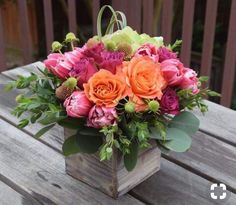 a wooden box with flowers in it sitting on a bench