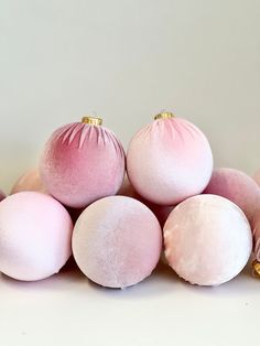 pink and white ornaments sitting on top of each other in front of a white wall