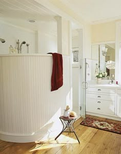 a bathroom with white walls and wooden floors